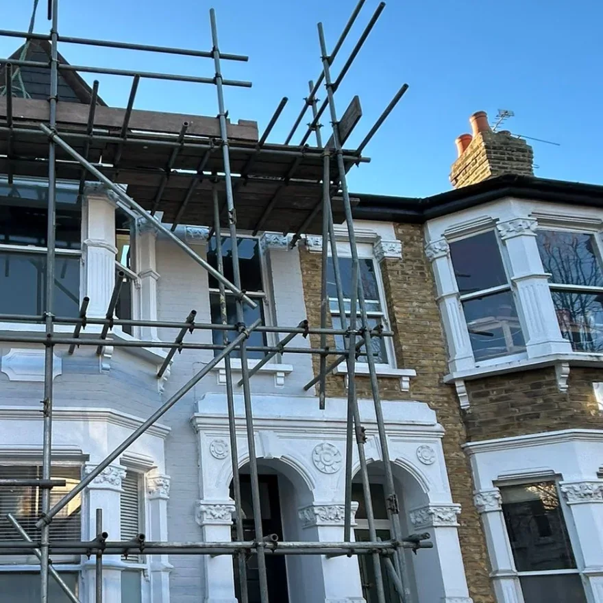 Scaffolding across the front of a white terraced house