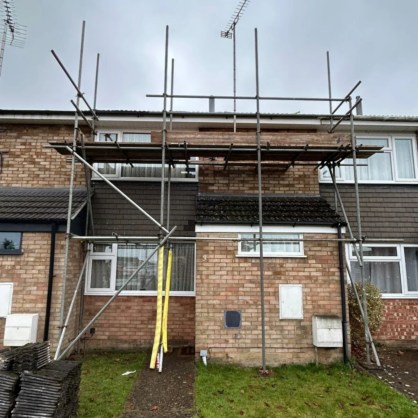 Scaffolding across the front of a brick residential building
