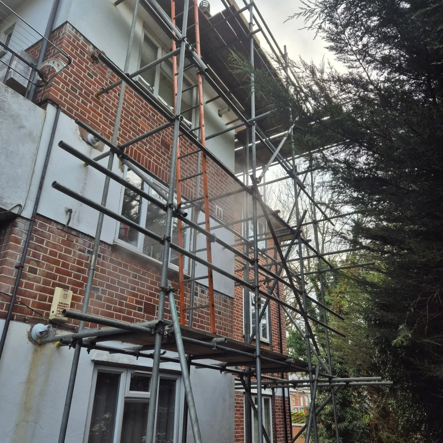 Scaffold structure beside a brick and rendered building